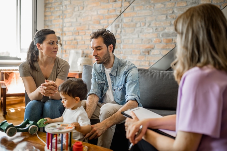 Young couple with a child on a therapy Young couple with a child on a therapy with a therapist. They are in their living room. Belgrade, Serbia