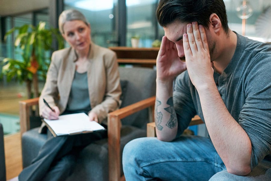 Patient with bipolar disorder holding his head