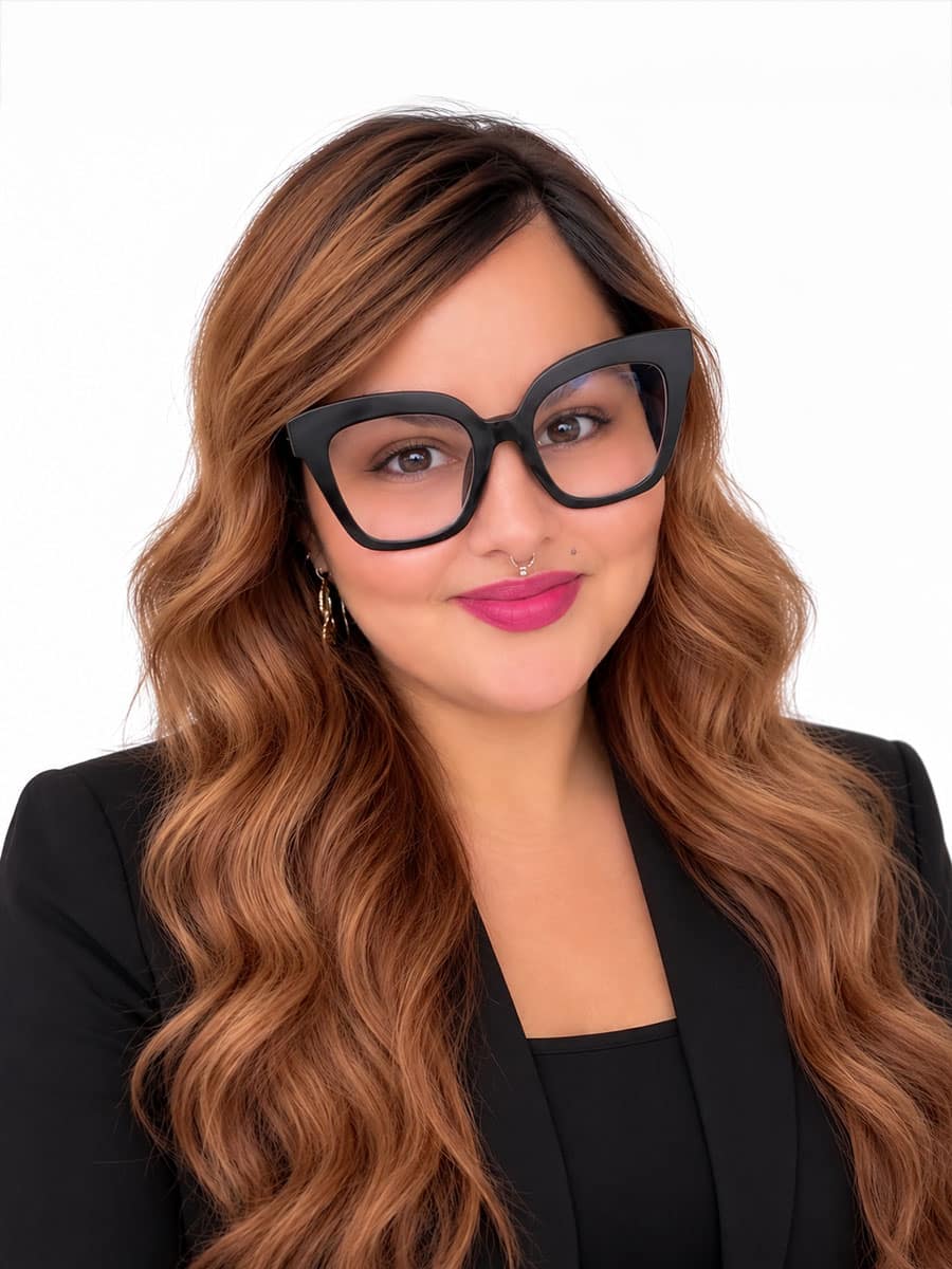 Dorothy J. Yarrington, an LMSW with long wavy brown hair, wearing thick black-framed glasses and a black blazer, smiles at the camera.